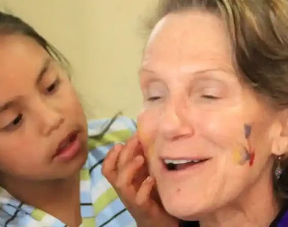 Kind schminkt eine Betreuerin im Refugio de los Suenios