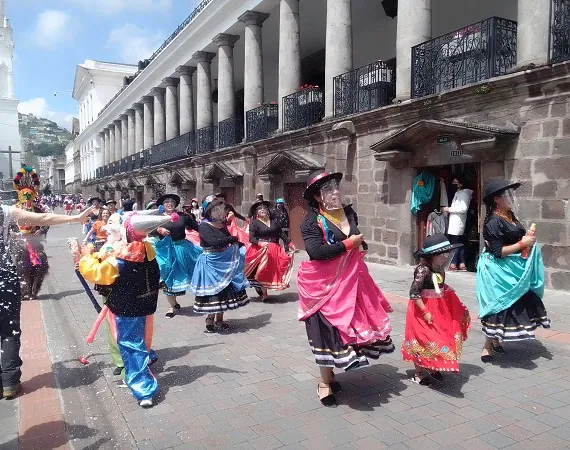 Sonne und ein bunter Karnevalsumzug in der Altstadt von Quito