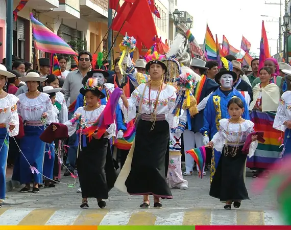 Indigene Kinder und Frauen in traditioneller Kleidung bei einem farbenfrohen Festumzug in Ecuador