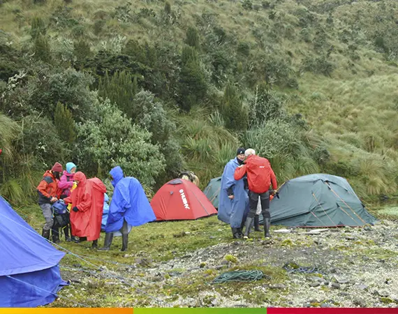 Gruppe von Wanderern beim Campen auf dem Condor Trek in Ecuador, umgeben von nebelverhangenen Bergen und Hochlandlandschaften.