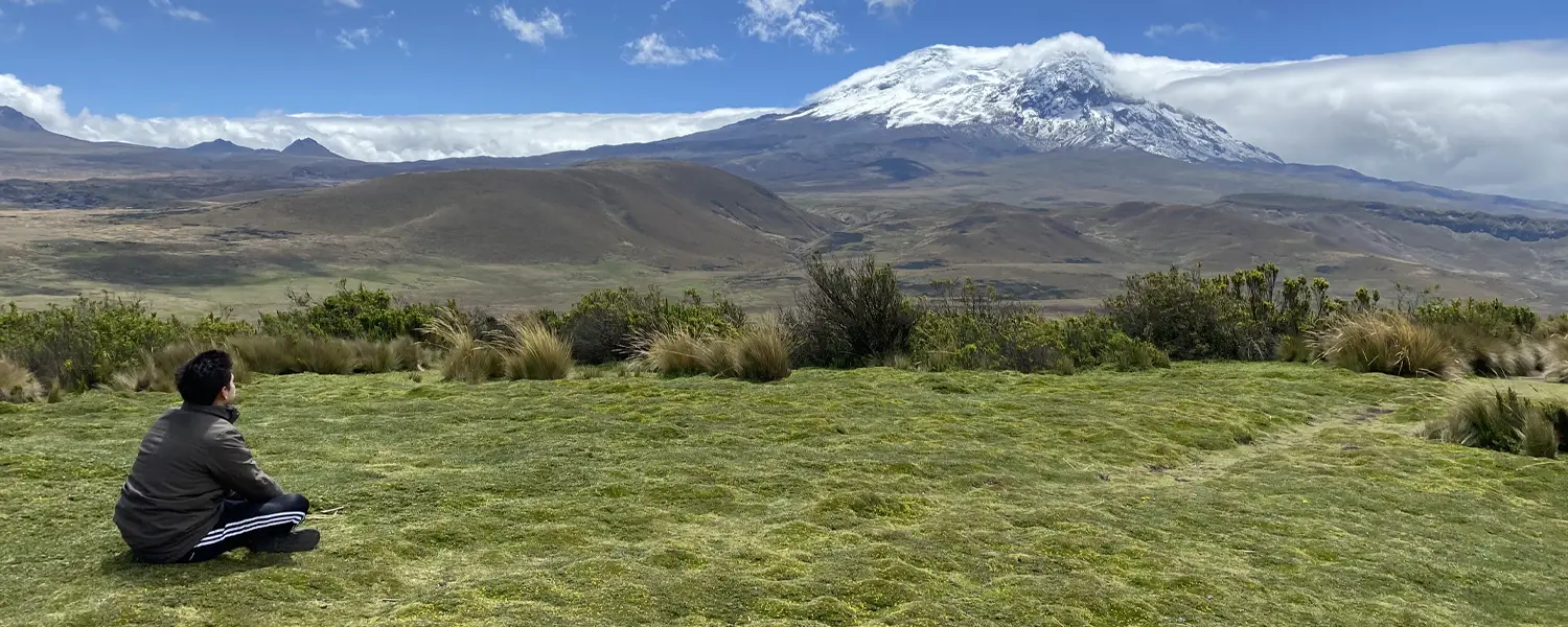 Reisender betrachtet den schneebedeckten Vulkan Antisana – Vulkane in Ecuador in ihrer spirituellen Dimension