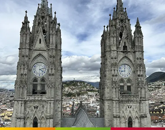 Die neugotischen Türme der Basílica del Voto Nacional in Quito mit Blick auf El Panecillo im Hintergrund.