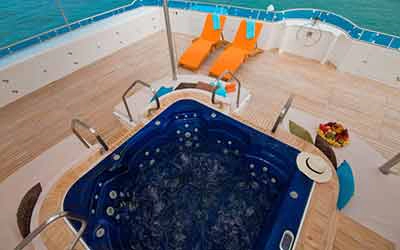 Liegen und Jacuzzi auf dem Sonnendeck auf dem Erste Klasse Galapagos Katamaran Cormorant
