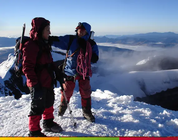 Zwei Bergsteiger auf dem schneebedeckten Gipfel des Cotopaxi-Vulkans in Ecuador bei Sonnenaufgang