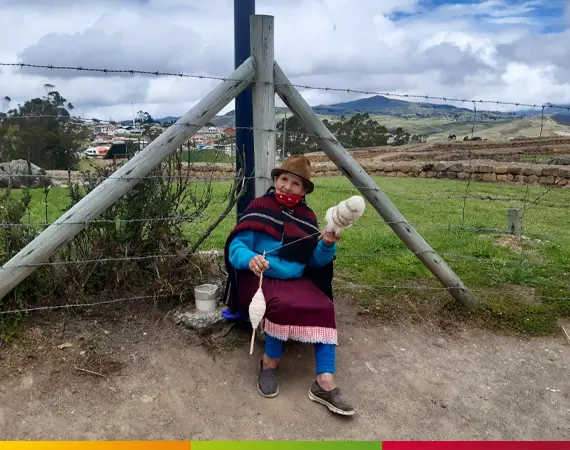 Indigene Frau spinnt Wolle in den Anden – gelebtes Handwerk auf der Kunstreise nach Ecuador